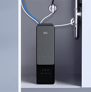A modern water filtration system with a sleek black and gray design is installed under a sink, with pipes and tubes connected to it for water filtration.